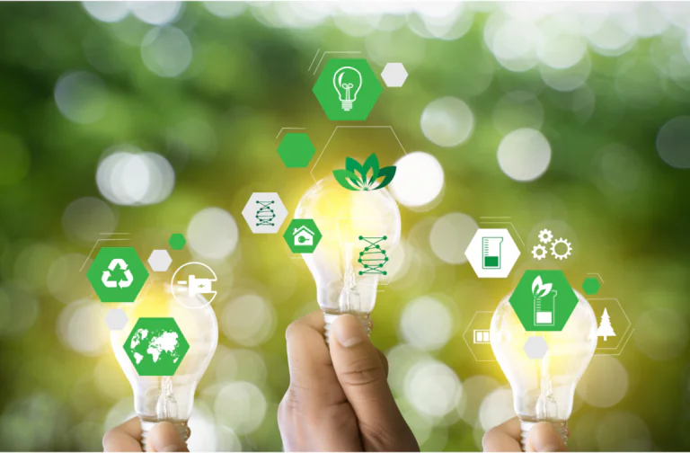 **Texto alternativo para a imagem:** Mãos segurando lâmpadas acesas, representando ideias e inovações sustentáveis. Sobre a imagem, ícones verdes de sustentabilidade, como reciclagem, energia limpa e proteção ambiental, destacam soluções ecológicas. O fundo desfocado com tons de verde reforça a conexão com a natureza e o compromisso com práticas sustentáveis e ESG.